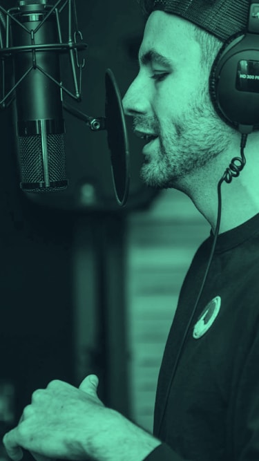 Man speaking into a mic, recording a podcast with a green overlay to give the vibe of the brand colour.